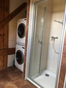 a bathroom with a shower and a washer and dryer at Guesthouse ''Chatonnaye'' 