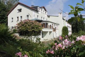 a white house with flowers in front of it at Hotel Carolaruh in Bad Elster