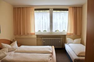 a room with two beds in front of a window at Hotel Carolaruh in Bad Elster