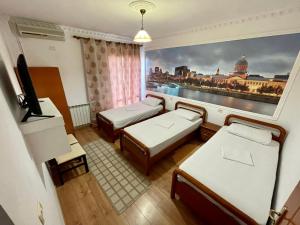 una habitación con 2 camas y una pintura de una ciudad en RAMIS Hotel & Outdoor Sports Center, en Përmet 37 fotos más