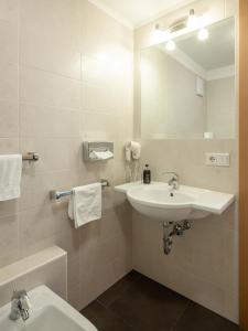 uma casa de banho com um lavatório e um espelho em Hotel Falken em Falzes