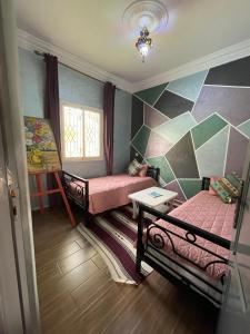 a small room with two beds and a table at Douja Ferme in Ouirgane