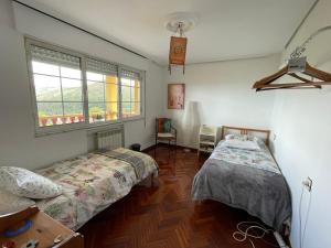 1 dormitorio con 2 camas y ventana en Ashram de La Peral, en Illas