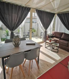 ein Wohnzimmer mit einem Tisch, Stühlen und einem Sofa in der Unterkunft Escapade charentaise in Aigrefeuille-dʼAunis