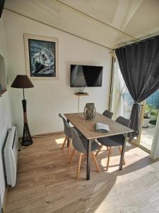 ein Esszimmer mit einem Holztisch und Stühlen in der Unterkunft Escapade charentaise in Aigrefeuille-dʼAunis