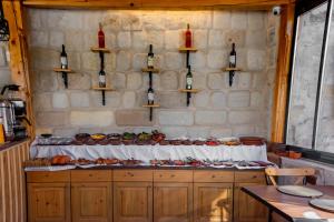 格雷梅的住宿－Sora Cave Hotel，厨房提供食品和葡萄酒瓶