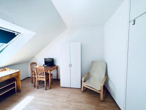 een zolderkamer met een bureau, stoelen en een tafel bij Möbliertes Apartment-Nahe Zeche Zollverein- in Essen