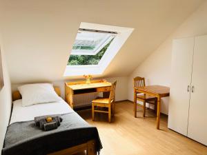 a bedroom with a bed and a desk and a window at Möbliertes Apartment-Nahe Zeche Zollverein- in Essen