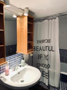 La salle de bains est pourvue d'un lavabo et d'un rideau de douche. dans l'établissement Odskocznia House, à Szczyrk
