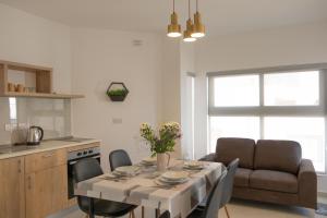 eine Küche und ein Esszimmer mit einem Tisch und einem Sofa in der Unterkunft Side-seaview apartment near beach and close to St. Julians in Baħar iċ-Ċagħaq