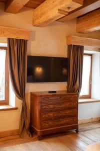 a living room with a tv and a wooden dresser at Al Capriolo in Vodo Cadore