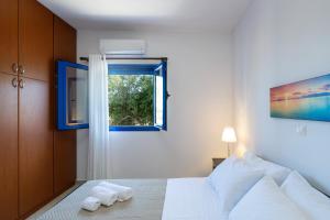 Votsalo في Khamaítoulon: غرفة نوم بسرير ابيض ونافذة
