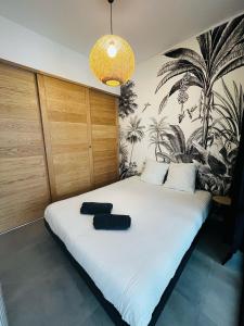 een slaapkamer met een bed met twee zwarte stoelen erop bij Joli T2 Moderne au Coeur de Marseille - Place Castellane in Marseille