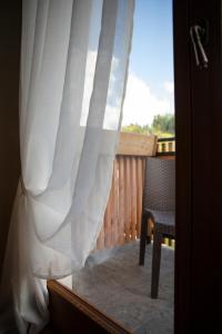 a view of a porch with a chair and a curtain at Al Capriolo in Vodo Cadore