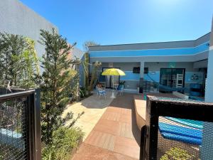 a house with a patio with a yellow umbrella at Hostel Quintal de Casa in Foz do Iguaçu