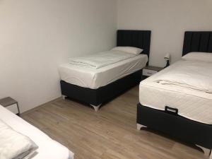 two twin beds in a room with wooden floors at Erbacher Ferienwohnung 2 in Erbach