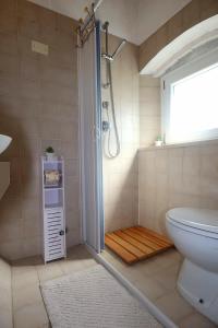 a bathroom with a shower with a toilet and a window at Wishlist - Casa Vacanze in Campiglia Marittima