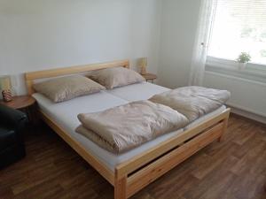 - un lit avec des draps et des oreillers blancs dans l'établissement Apartmány Jablunkov, à Jablunkov
