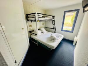 Voodi või voodid majutusasutuse Hôtel Gex toas