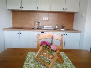 a table with vases of flowers and a picture frame on it at Apartmány Jablunkov in Jablunkov