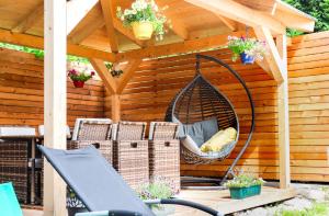 a swing hanging from a pergola in a garden at Imi Appartement in Eben im Pongau