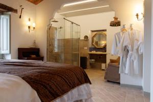 a bedroom with a bed and a glass shower at Casa bascara in Báscara