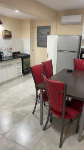 eine Küche mit einem Tisch und Stühlen sowie einem Kühlschrank in der Unterkunft Las Rejas Departamento in San Fernando del Valle de Catamarca