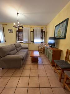 uma sala de estar com um sofá e uma mesa em Apartamentos Los Parrales em Villalba de la Sierra