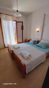a bedroom with a large bed with blue pillows at Cozy & Comfort in Polykhrono