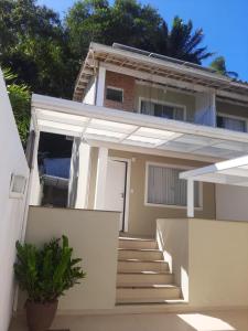 una casa blanca con escaleras delante en Village Praia Dourada - Praia dos Milionários en Ilhéus