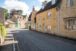 an empty street in an old town with brick buildings at 2 Candlemas Cottage in Bourton on the Water