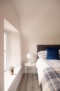 - une chambre avec un lit doté d'un oreiller bleu et d'une table dans l'établissement Kilcon Farmhouse (Newry -Armagh), 