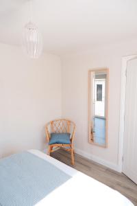 - une chambre avec un lit, une chaise et un miroir dans l'établissement Kilcon Farmhouse (Newry -Armagh), 