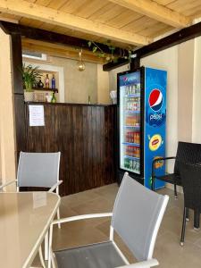 uma máquina de refrigerante de cocacola num restaurante com mesas e cadeiras em Thermal Family Resort em Baile Felix