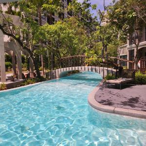 ein großer Pool mit Brücke in einem Gebäude in der Unterkunft Apple's La casita condo in Hua Hin in Hua Hin