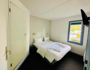 Voodi või voodid majutusasutuse Hôtel Gex toas