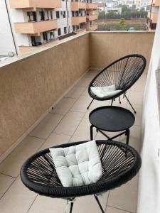 Un balcón con 2 sillas y una almohada. en Luna Luxury Apartment by the Zoo en Râmnicu Vâlcea