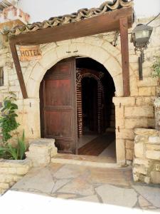 une entrée à un hôtel avec une grande porte en bois dans l'établissement Hotel Nasho Vruho, à Berat