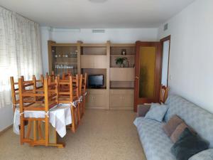 a living room with a couch and a table and chairs at Apartamento con vistas al mar y buena ubicación in Benicàssim