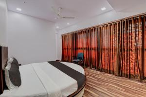 a bedroom with a bed and a large curtain at Collection O Hotel Royal Inn in Ahmedabad
