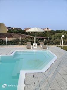 - une piscine avec 2 chaises et un parasol dans l'établissement Al Mare da Francesca, à Olbia