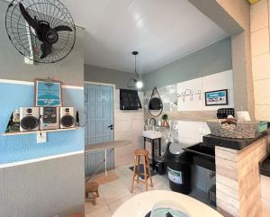 a room with a kitchen with a fan on the wall at Hostel Quintal de Casa in Foz do Iguaçu