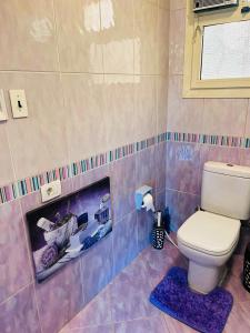 a bathroom with a toilet and a picture on the wall at Luxury & spacious 3BD Apartment in family house in Cairo