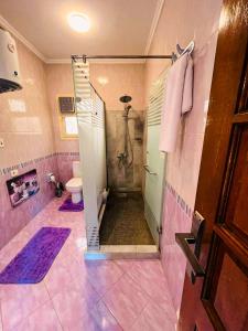 y baño de color rosa con ducha y aseo. en Luxury & spacious 3BD Apartment in family house en El Cairo