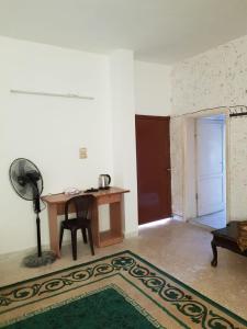 a room with a desk and a table with a fan at Abuawad Rental in Jerash