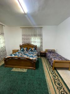 a bedroom with two beds and a green carpet at Abuawad Rental in Jerash