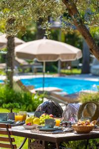 Hotel La Garbine في سانت تروبيز: طاولة عليها طعام وفواكه بجانب مسبح