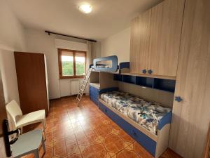 Appartamento Incantevole a Follonica Mare- 5 posti في فولونيكا: غرفة صغيرة مع سرير بطابقين وسلم +15 صورة