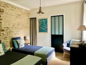 - une chambre avec deux lits et une chaise dans l'établissement Holiday home L'Autre Maison, à Saint-Jean-de-Ceyrargues