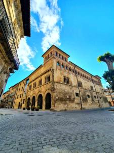 a large stone building with a tower on a street at Apartamento Ábside de San Juan III in Estella